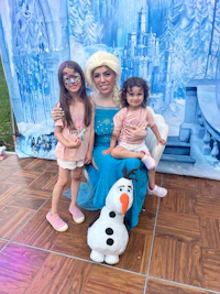 olaf, elsa, and anna pose for a photo in front of a frozen backdrop