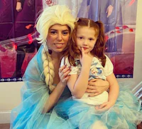 a woman dressed as elsa and a little girl posing for a picture